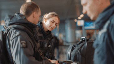 Une police des frontières vérifiant le passeport d'un passager