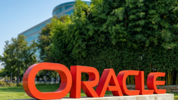 Vue rapprochée du logo d'Oracle à l'extérieur de leurs bureaux pour illustrer le déploiement d'agents IA en cours.