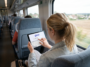 Jeune femme dans un train effectuant une recherche avec Glean Search sur sa tablette.