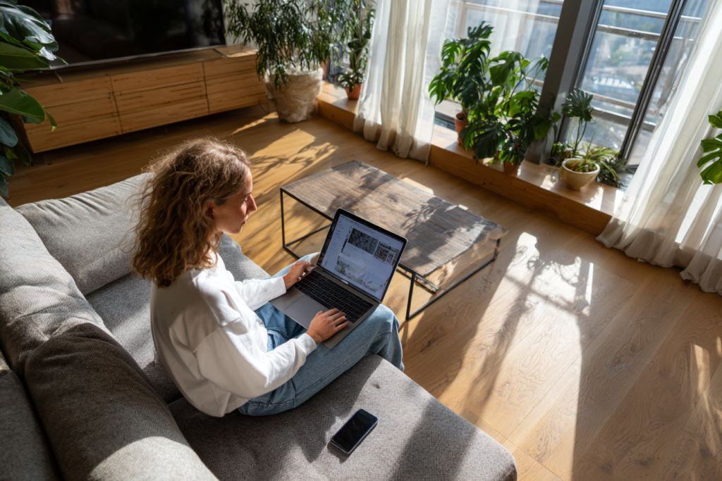 Créatrice de contenu gérant son calendrier éditorial sur le Marketing Hub HubSpot depuis un studio de travail moderne et lumineux, engagement social sur smartphone.