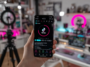 POV d'une personne tenant son smartphone avec le logo en charge de TikTok et des options de téléchargement et d'édition